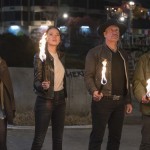 Abigail Breslin, Emma Stone, Woody Harrelson, and Jesse Eisenberg hold torches while looking up in Zombieland: Double Tap