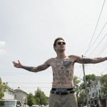 Pete Davidson shirtless with sunglasses and arms outstretched in the movie The King of Staten Island