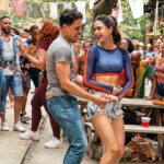 Anthony Ramos and Melissa Barrera dance together in front of a crowd in the musical In The Heights