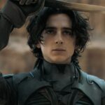 Timothée Chalamet holds a knife and looks at it in the movie Dune