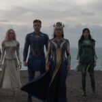 The heroes in the film the Eternals all stand together on a beach