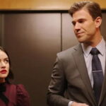 Lucy Hale and Austin Stowell stand akwardly in an elevator looking at each other in the movie The Hating Game