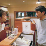 A man and woman stand on opposite sides of a counter at a restaurant staring each other down in the film Beyond the Infinite Two Minutes