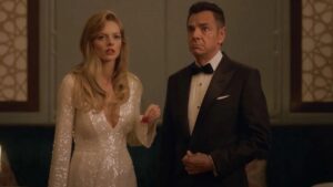 Samara Weaving and Eugenio Derbez stand together in formal clothes in the movie The Valet