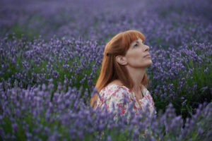 Siobhan Hewlett sits in a field of purple flowers looking up in the movie The Lost Girls