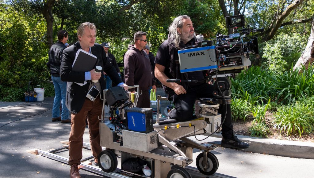 Hoyte Van Hoytema riding on a camera rig next to Christopher Nolan working on the movie Oppenheimer.