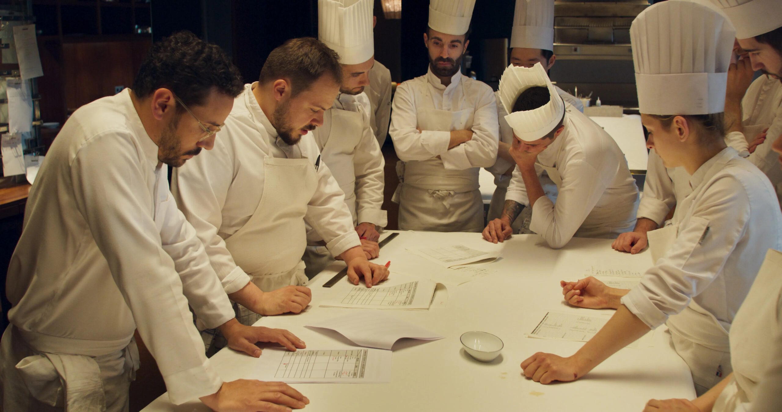 Chefs stand around a table in the documentary Menus-Plaisirs - Les Troisgros