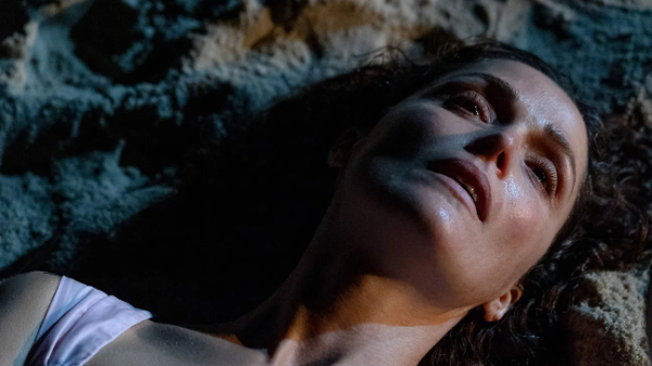 Rose Byrne looks defeated lying on a beach in the film If I Had Legs I'd Kick You.